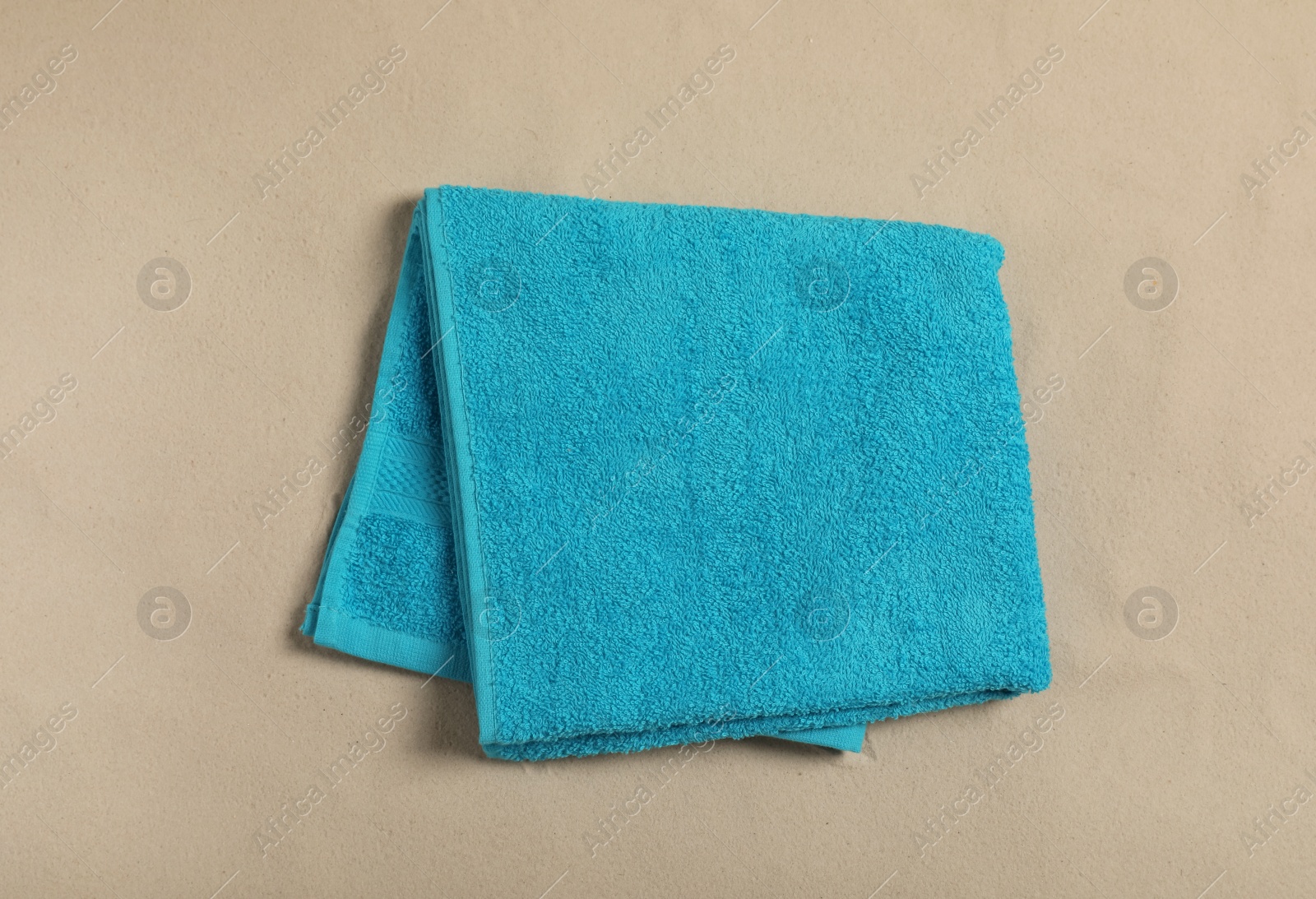 Photo of Light blue beach towel on sand, top view