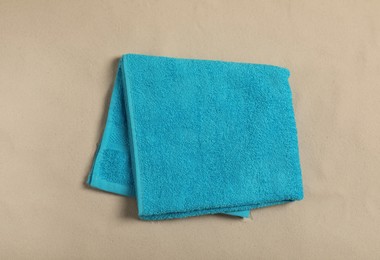 Light blue beach towel on sand, top view