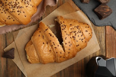 Flat lay composition with tasty croissants and chocolate on wooden table