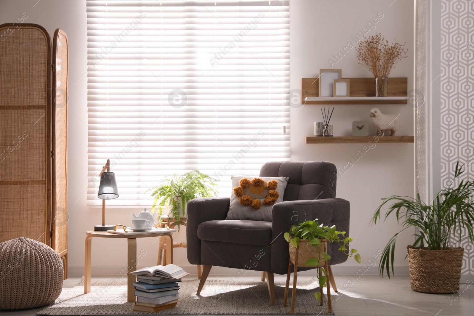 Photo of Comfortable place for rest with armchair near window in room