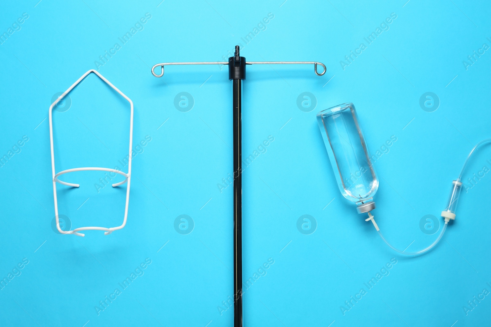 Photo of IV infusion set on light blue background, flat lay