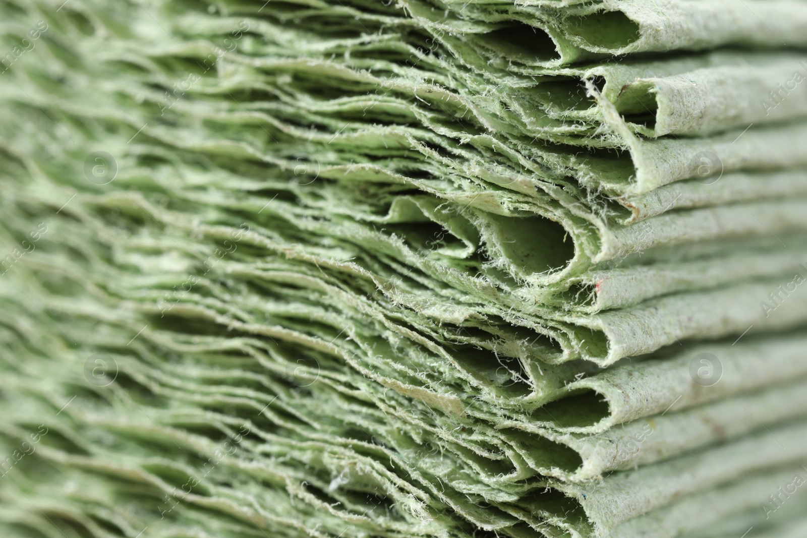 Photo of Texture of stacked light green paper napkins as background, macro view