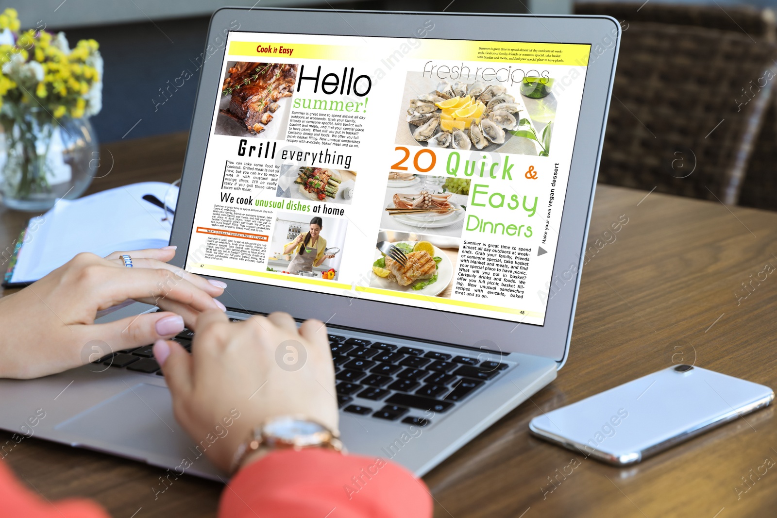 Photo of Woman reading online magazine on laptop at wooden table, closeup