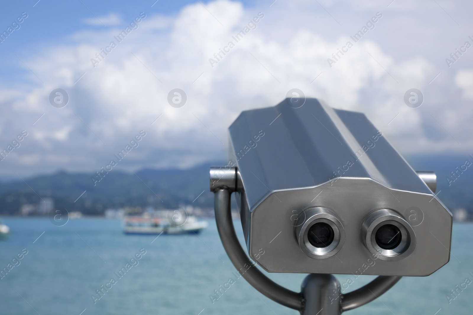 Photo of Metal tower viewer installed near sea, space for text. Mounted binoculars