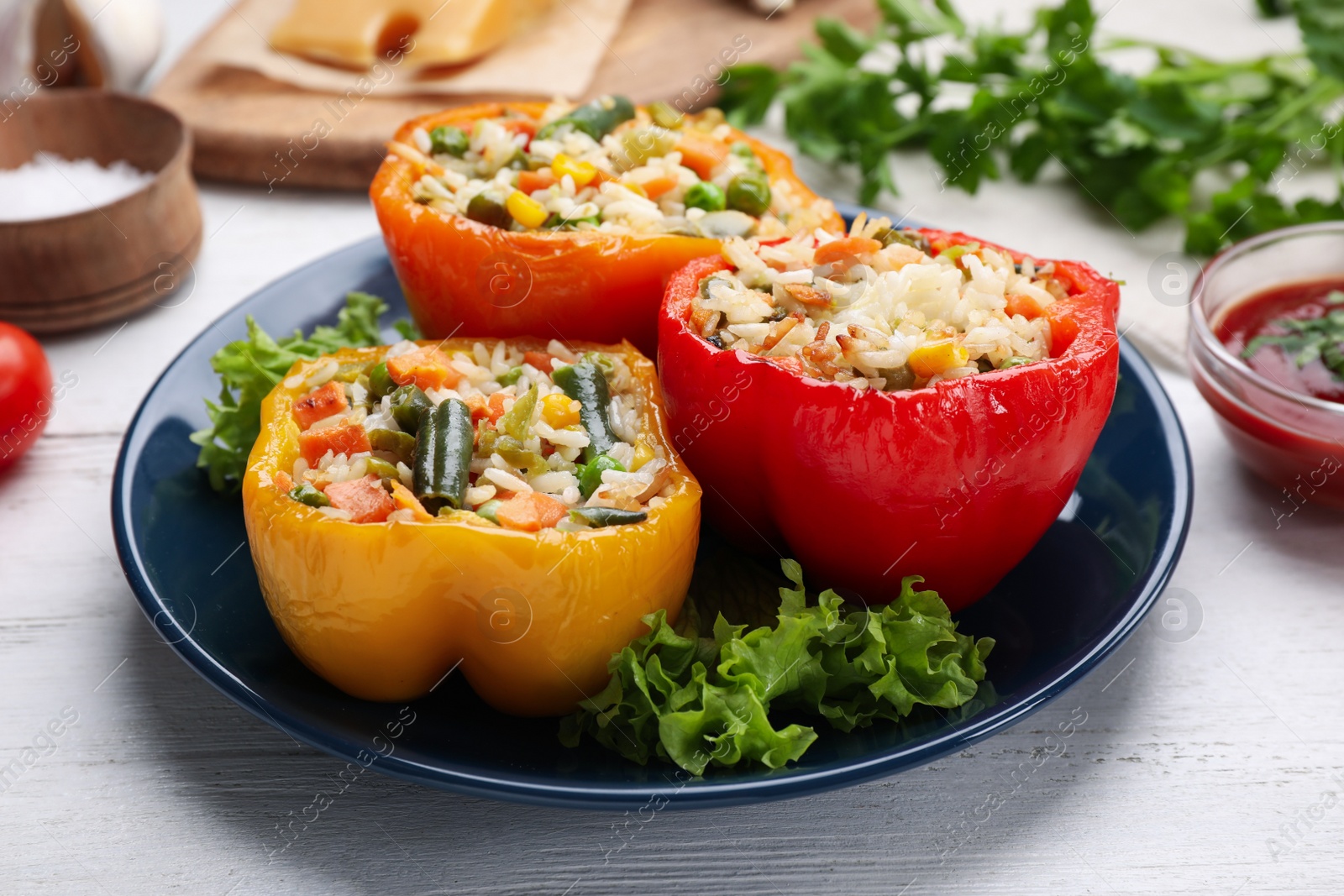 Photo of Tasty stuffed bell peppers served on white wooden table