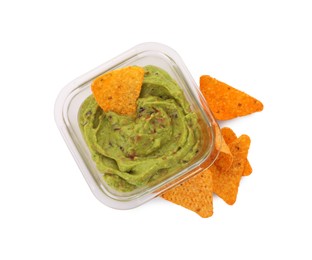 Photo of Bowl of delicious guacamole with nachos chips isolated on white, top view