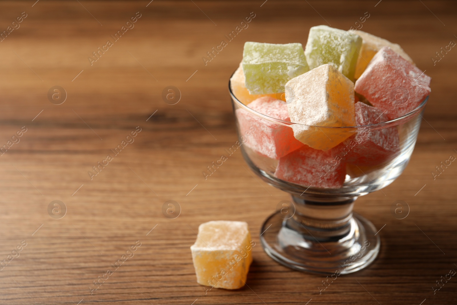 Photo of Turkish delight dessert on wooden table. Space for text