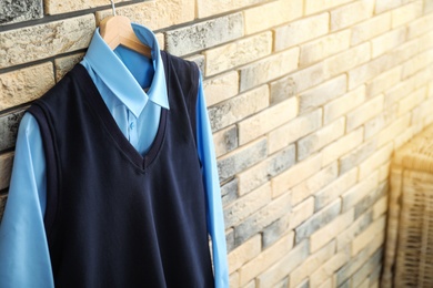 Photo of School uniform for boy hanging on brick wall