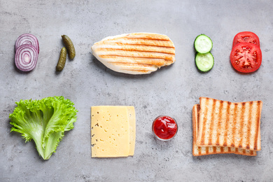 Fresh ingredients for tasty sandwich on light grey background, flat lay