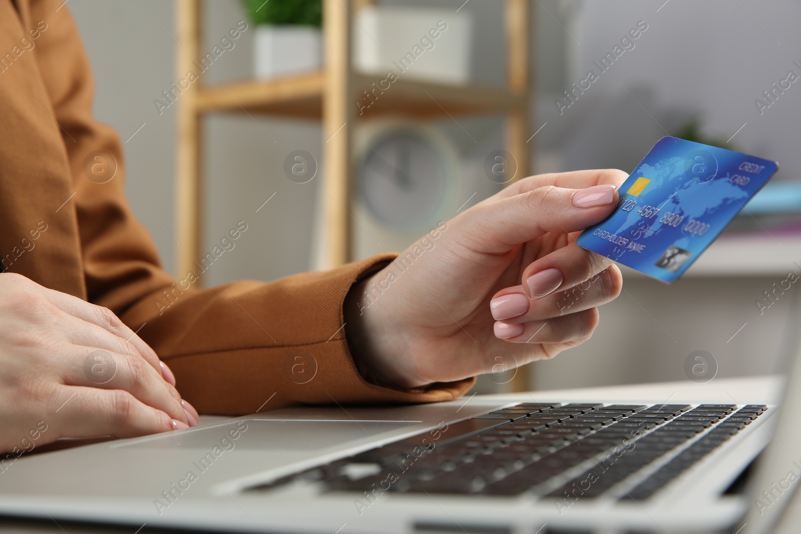 Photo of Online payment. Woman with credit card using laptop indoors, closeup