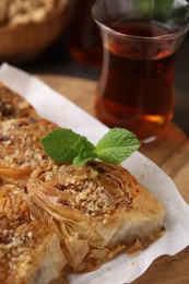 Photo of Eastern sweets. Pieces of tasty baklava and tea on table, closeup