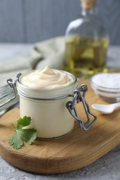 Photo of Tasty mayonnaise in jar and parsley on table, closeup