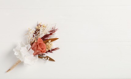 Photo of Beautiful boutonniere on white background, top view. Space for text