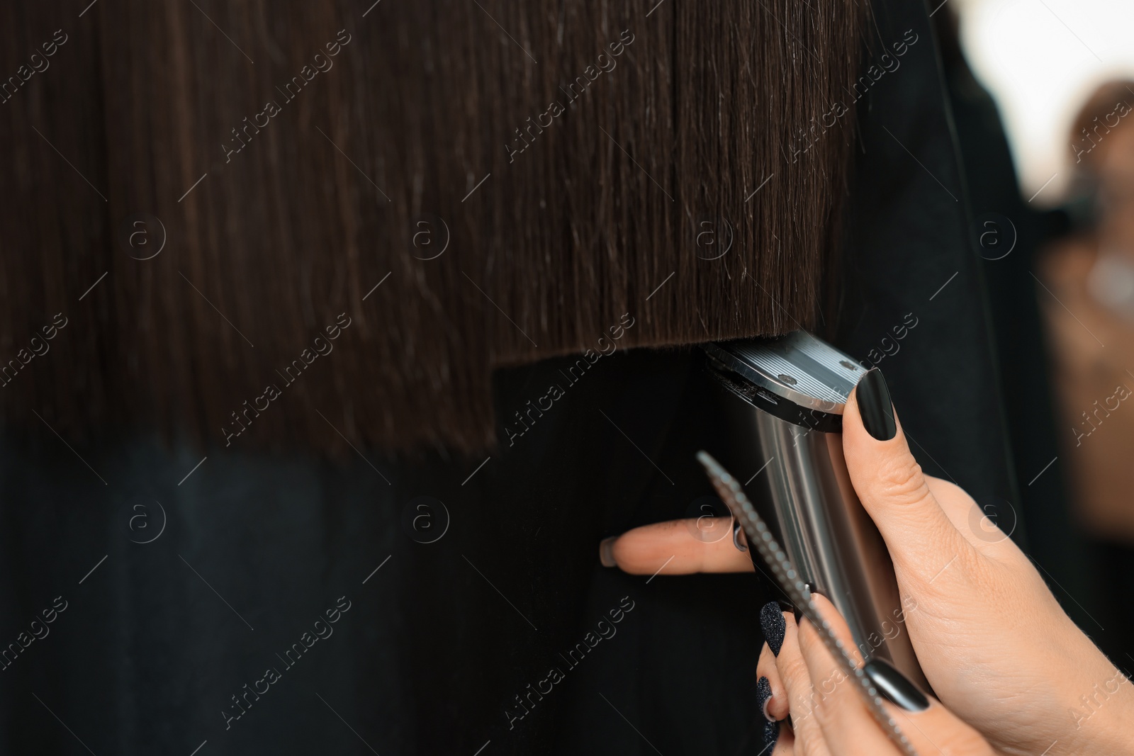 Photo of Professional hairdresser cutting woman's hair, closeup view