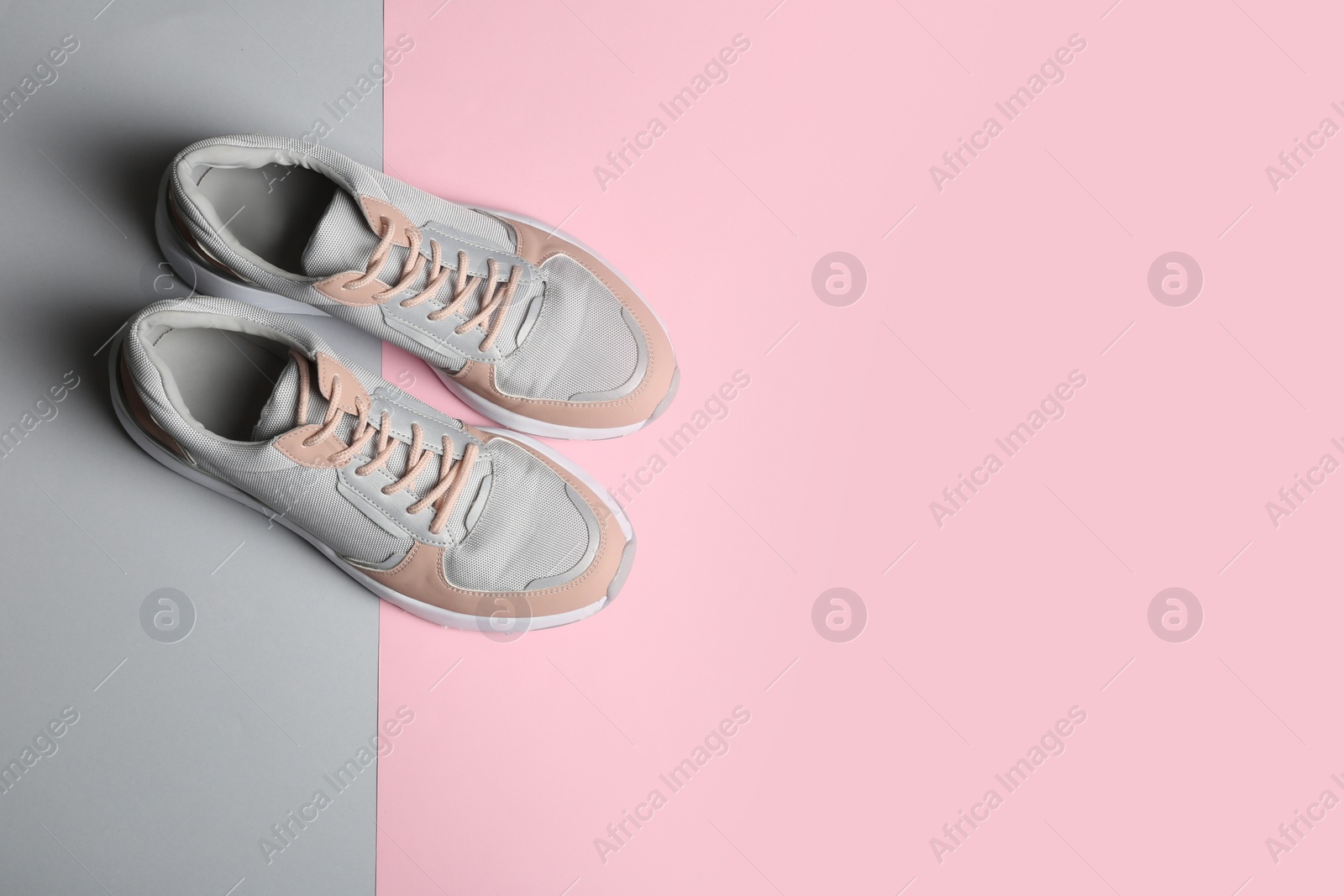 Photo of Pair of sports shoes on color background, top view. Space for text