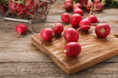 Photo of Fresh red ripe radishes on wooden table