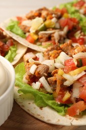 Photo of Delicious tacos with vegetables and meat on table, closeup