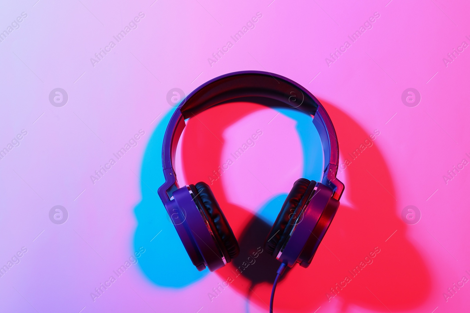 Photo of Stylish headphones on color background, top view