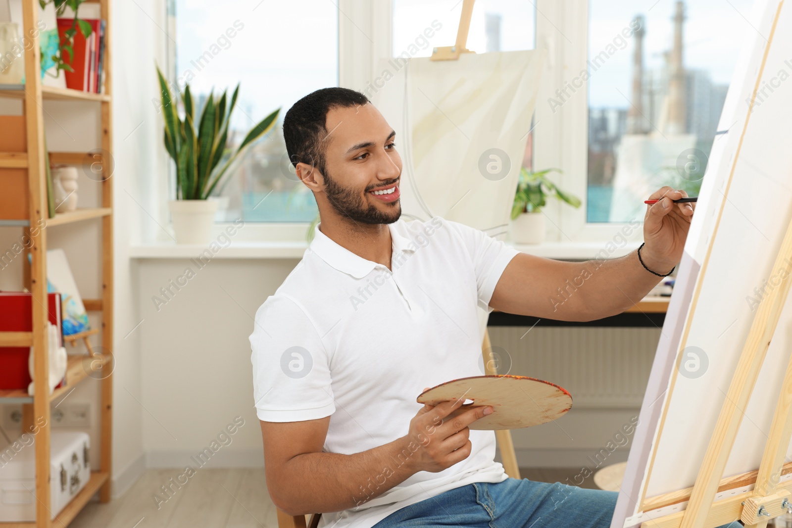 Photo of Young man painting in studio. Creative hobby