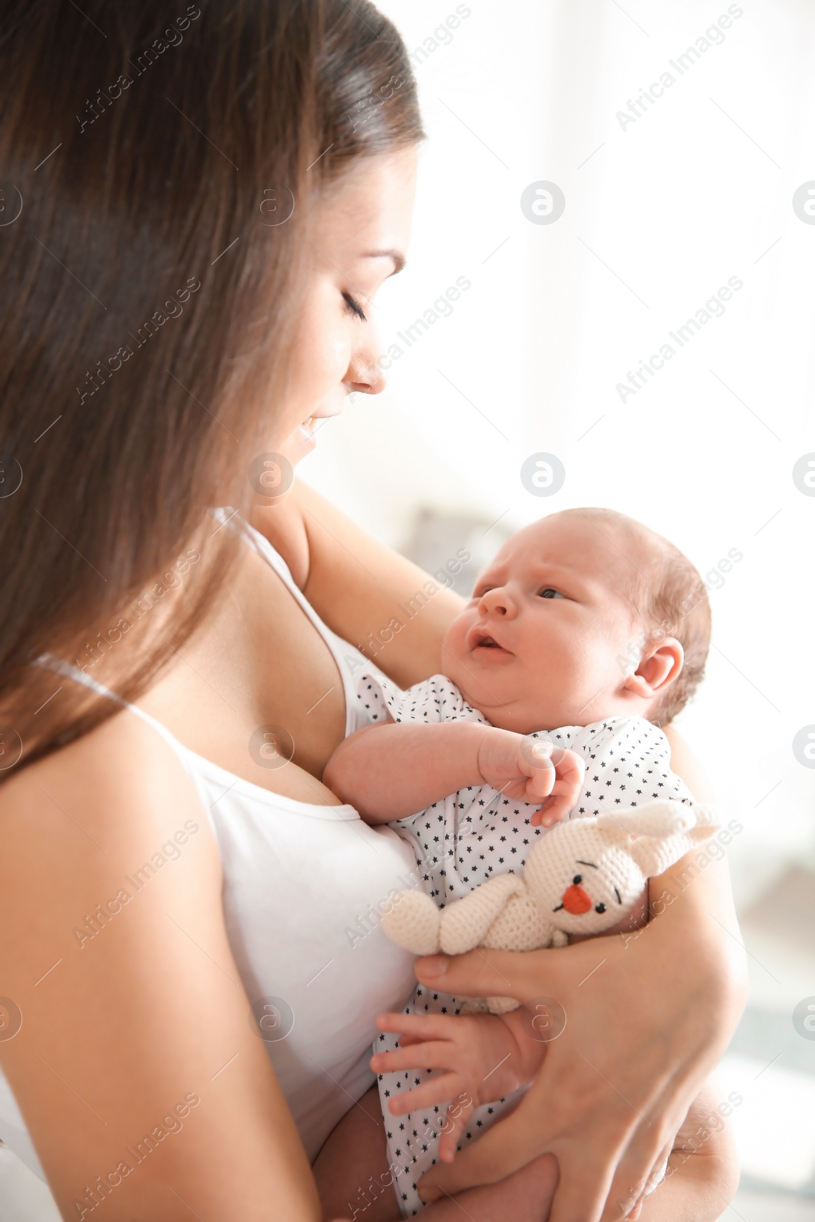 Photo of Young woman with her newborn baby on blurred background