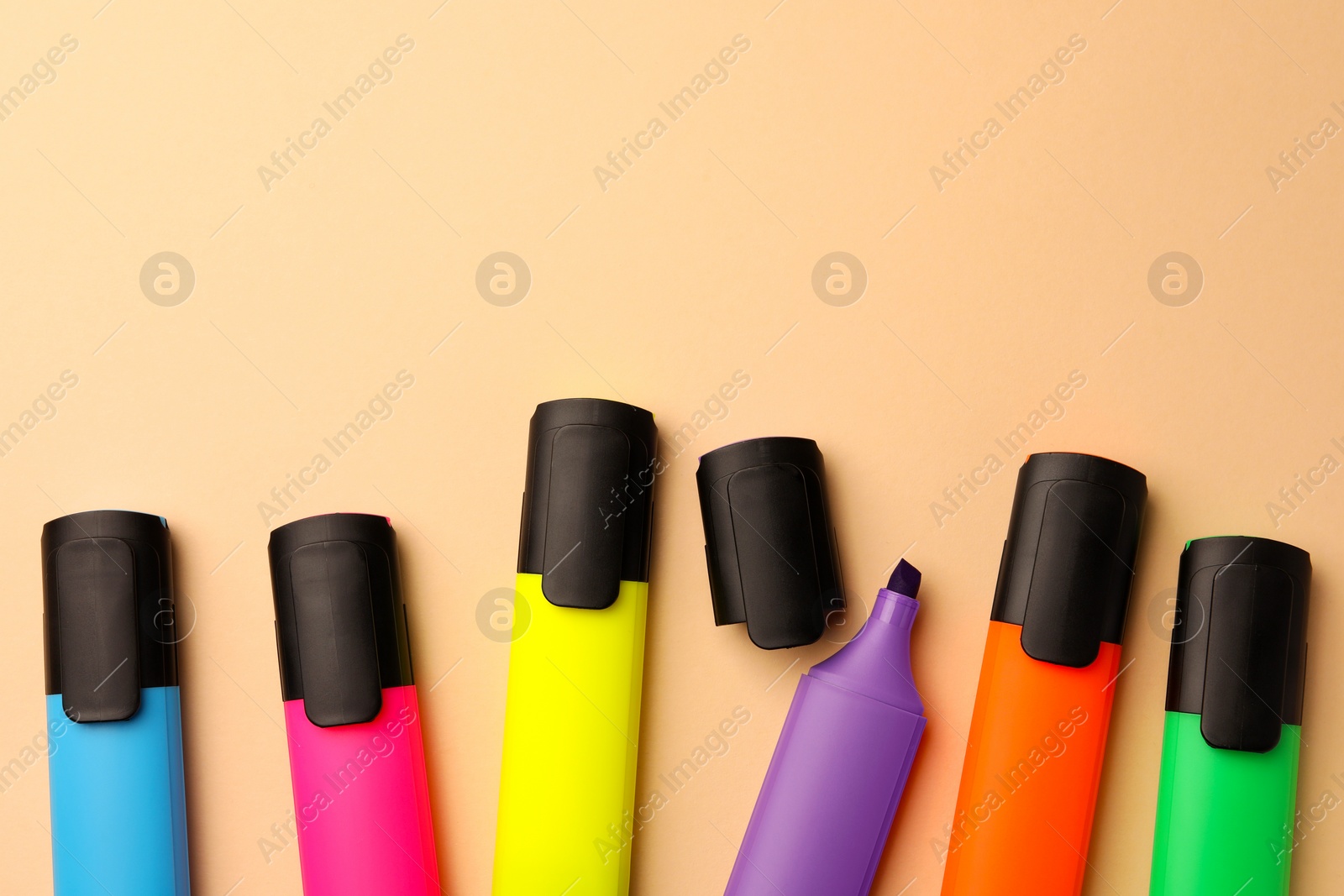 Photo of Bright color markers on beige background, flat lay. Space for text