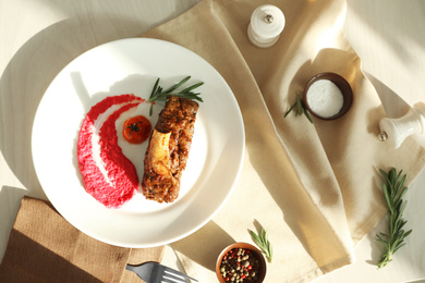 Delicious roasted rib served on white wooden table, flat lay