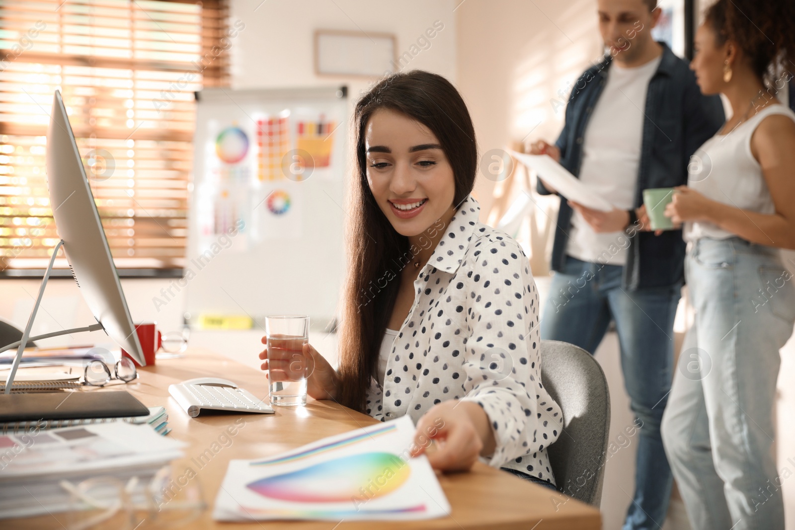 Photo of Portrait of happy female designer in office