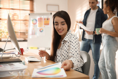 Portrait of happy female designer in office