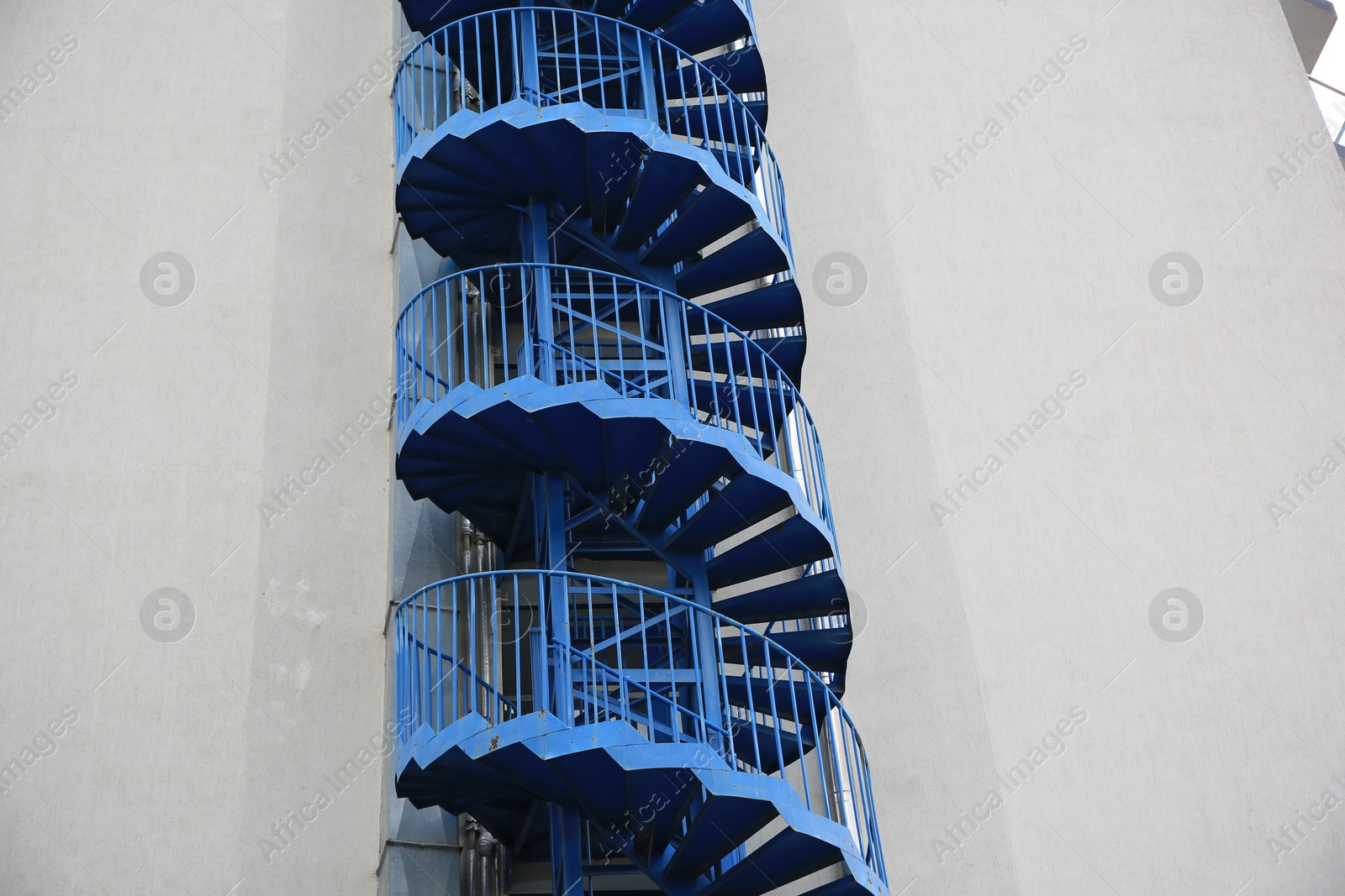 Photo of View of modern metal empty fire escape ladder near building outdoors