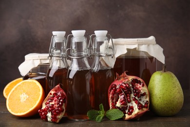 Tasty kombucha, mint and fresh fruits on wooden table