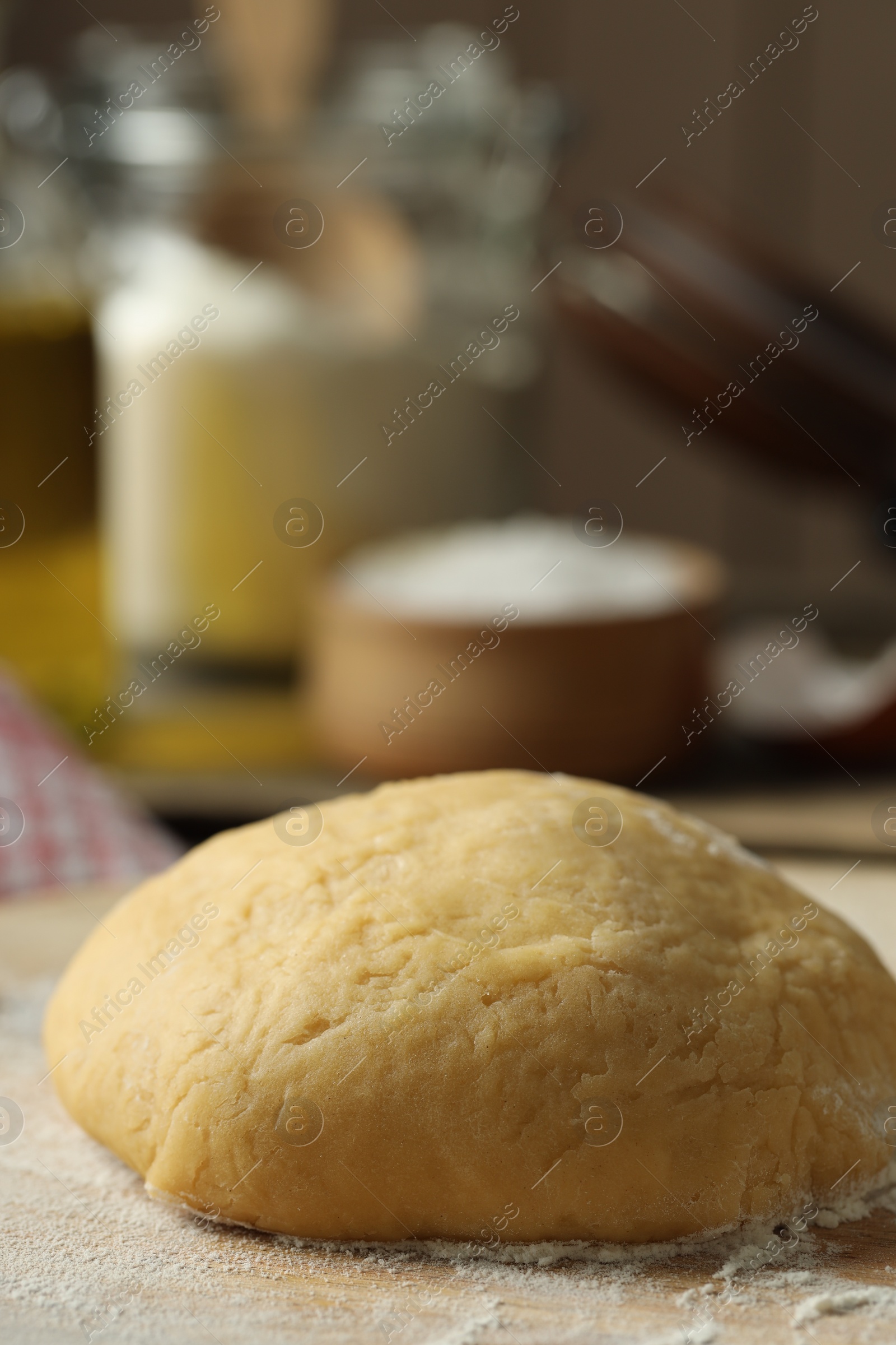 Photo of Raw dough and flour on table, closeup