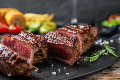 Photo of Delicious sliced beef steak served on table, closeup