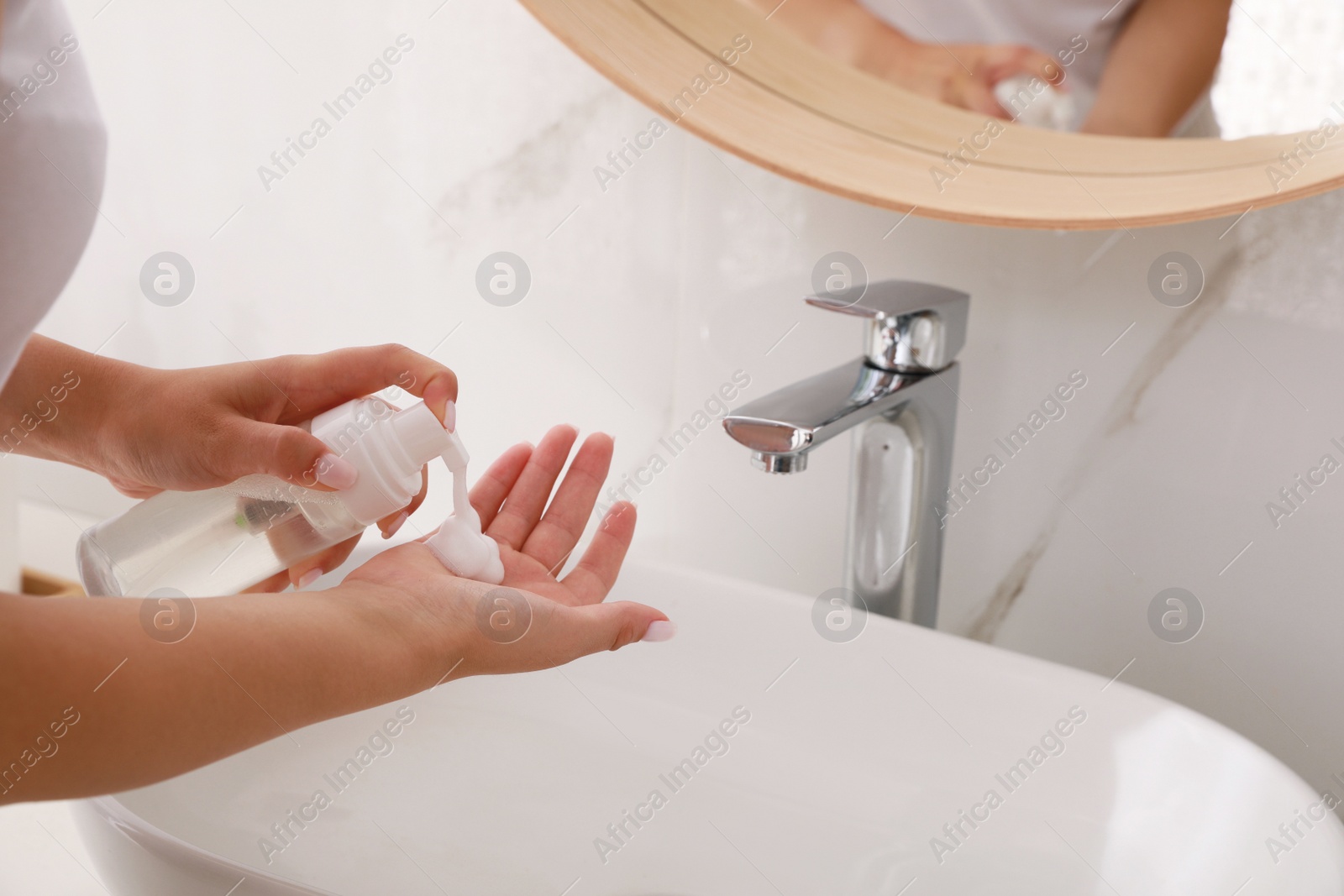 Photo of Teenage girl using cleansing foam in bathroom, closeup. Skin care cosmetic
