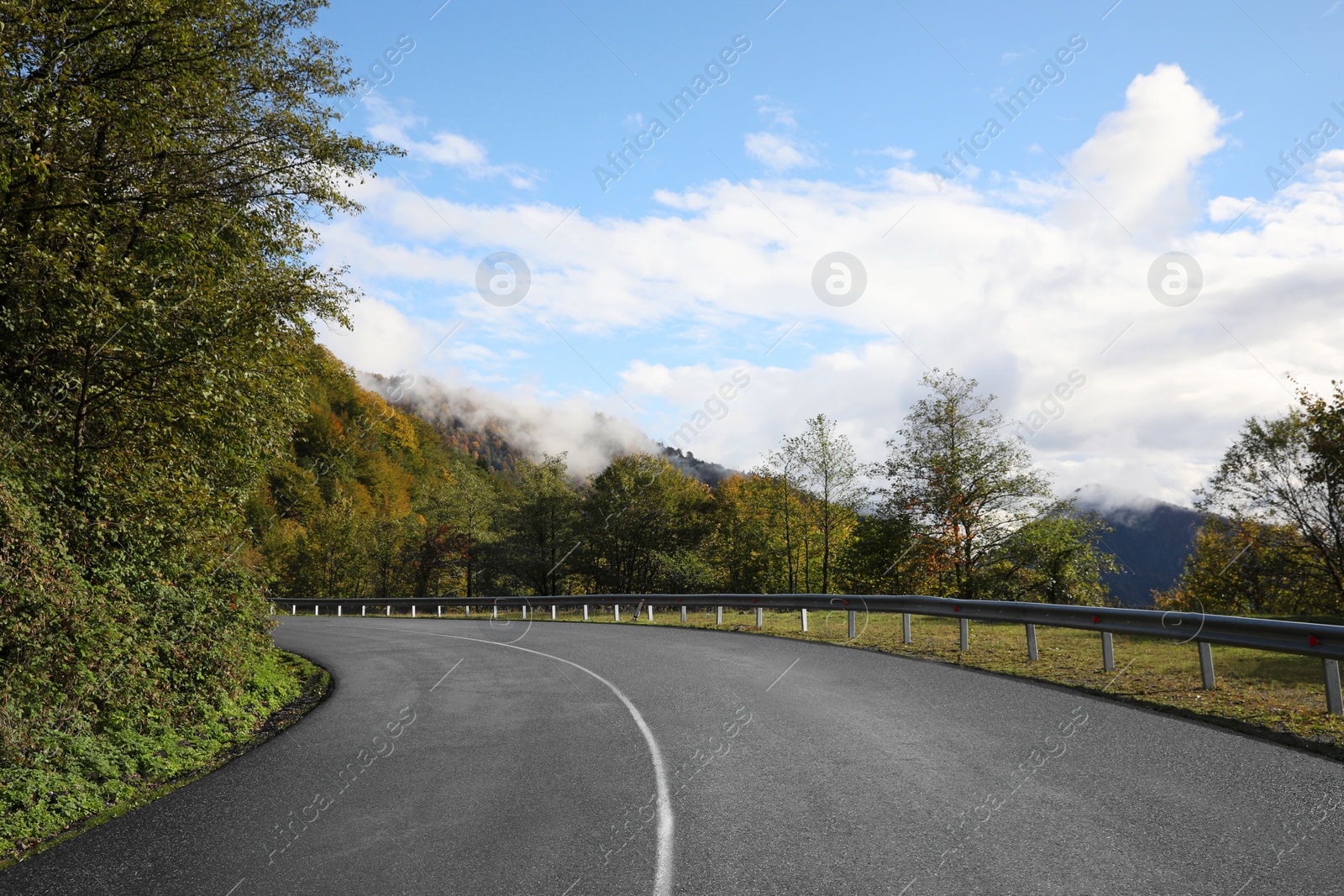 Photo of Picturesque view of empty road near trees in mountains