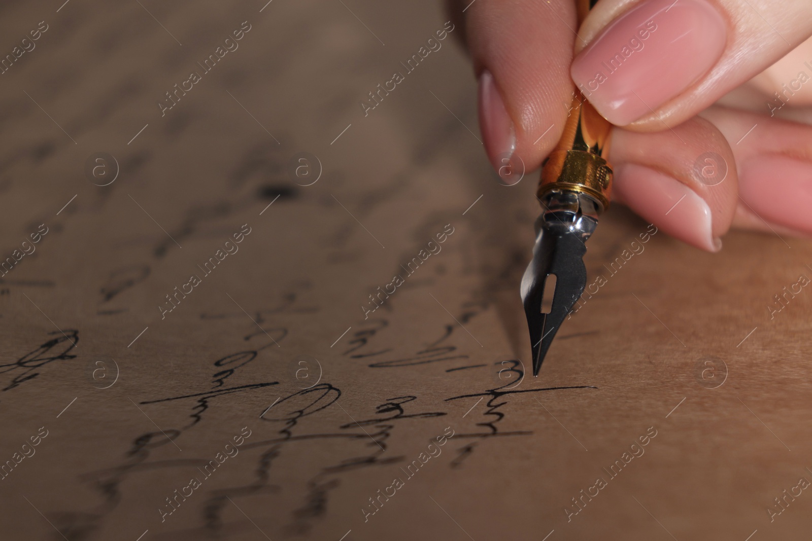 Photo of Woman writing letter with fountain pen, closeup