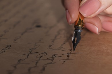 Photo of Woman writing letter with fountain pen, closeup