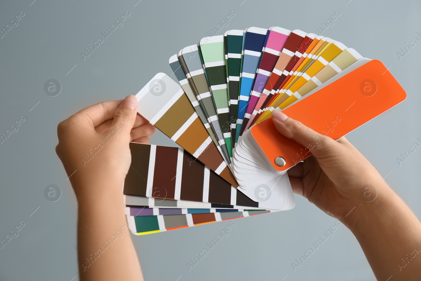 Photo of Female interior designer with palette samples on color background, closeup