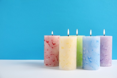 Photo of Alight wax candles on color background. Space for text