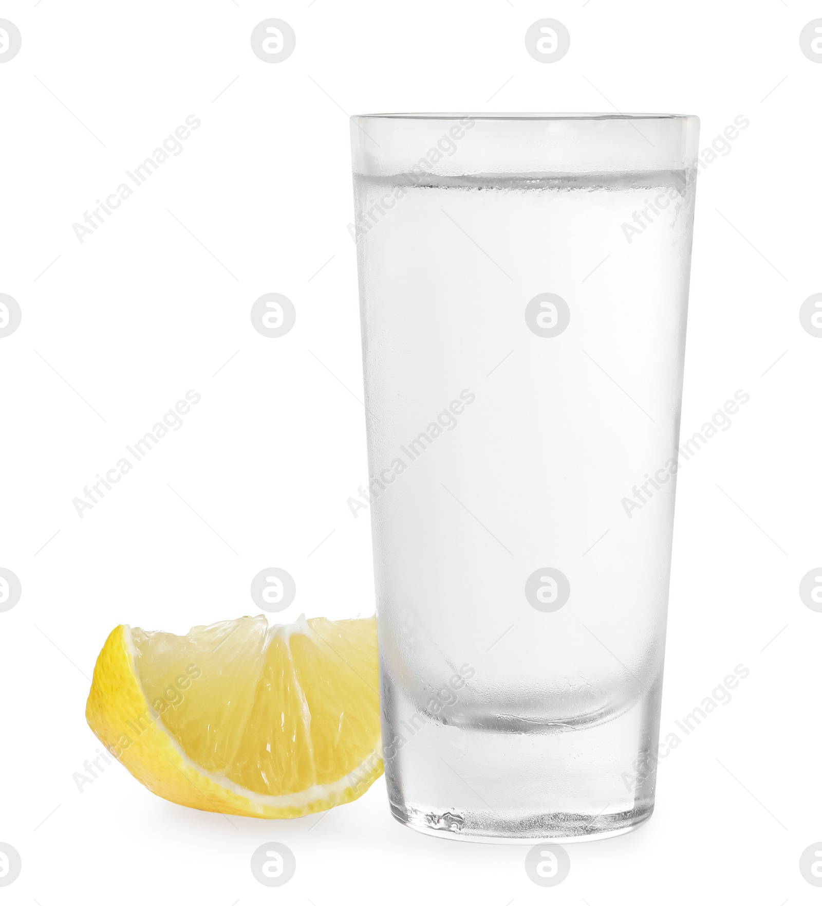 Photo of Glass of vodka and lemon isolated on white