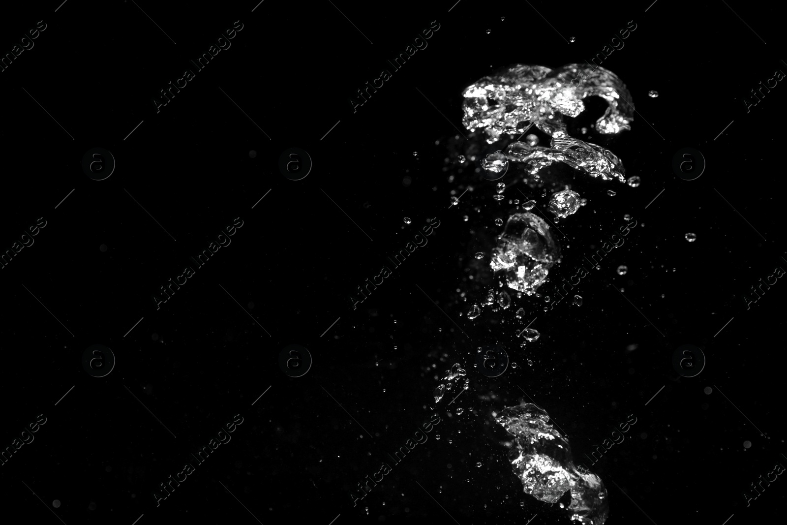 Photo of Air bubbles in water on black background, space for text