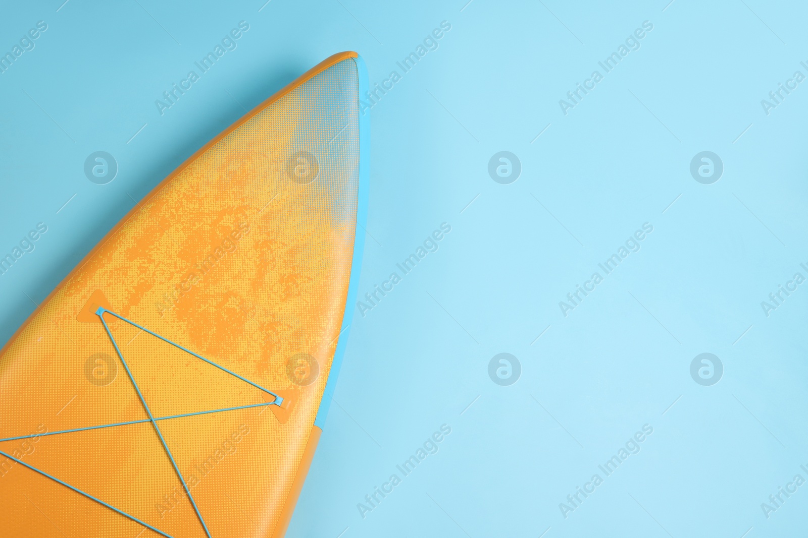 Photo of One SUP board on light blue background, top view with space for text. Water sport