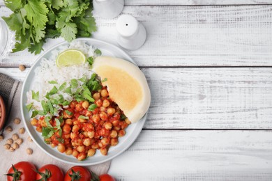 Photo of Delicious chickpea curry with rice served on white wooden table, flat lay. Space for text