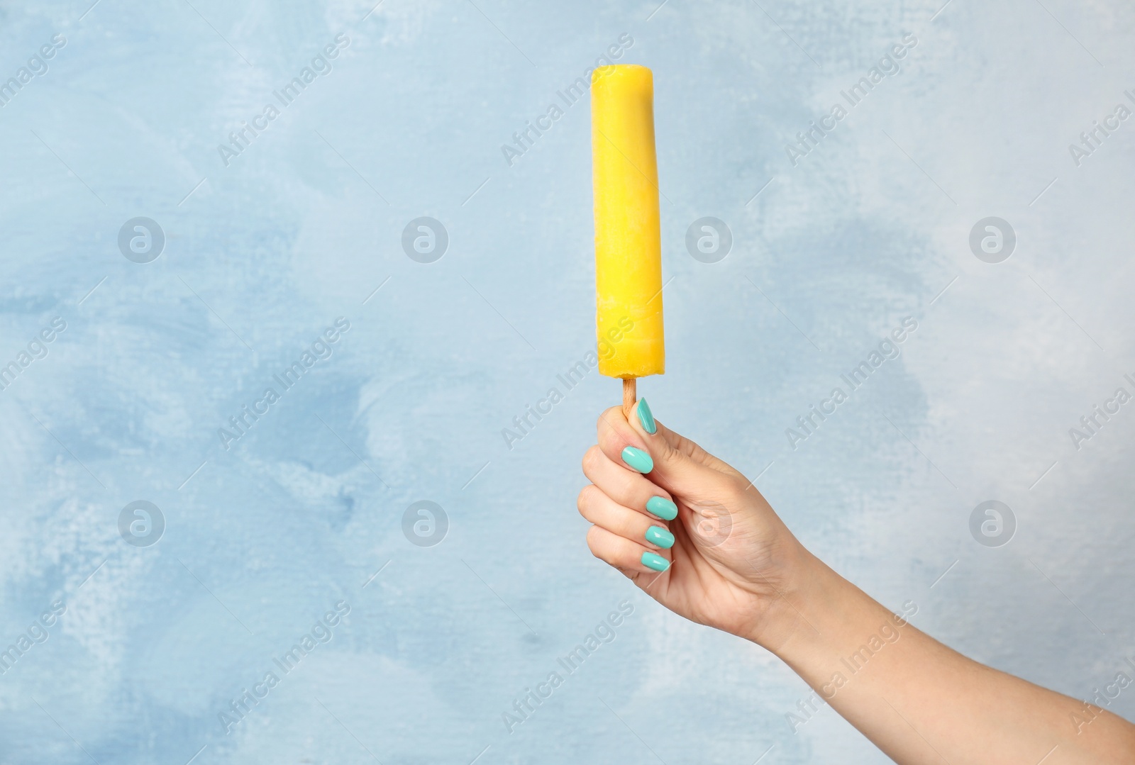 Photo of Woman holding yummy ice cream on color background. Focus on hand