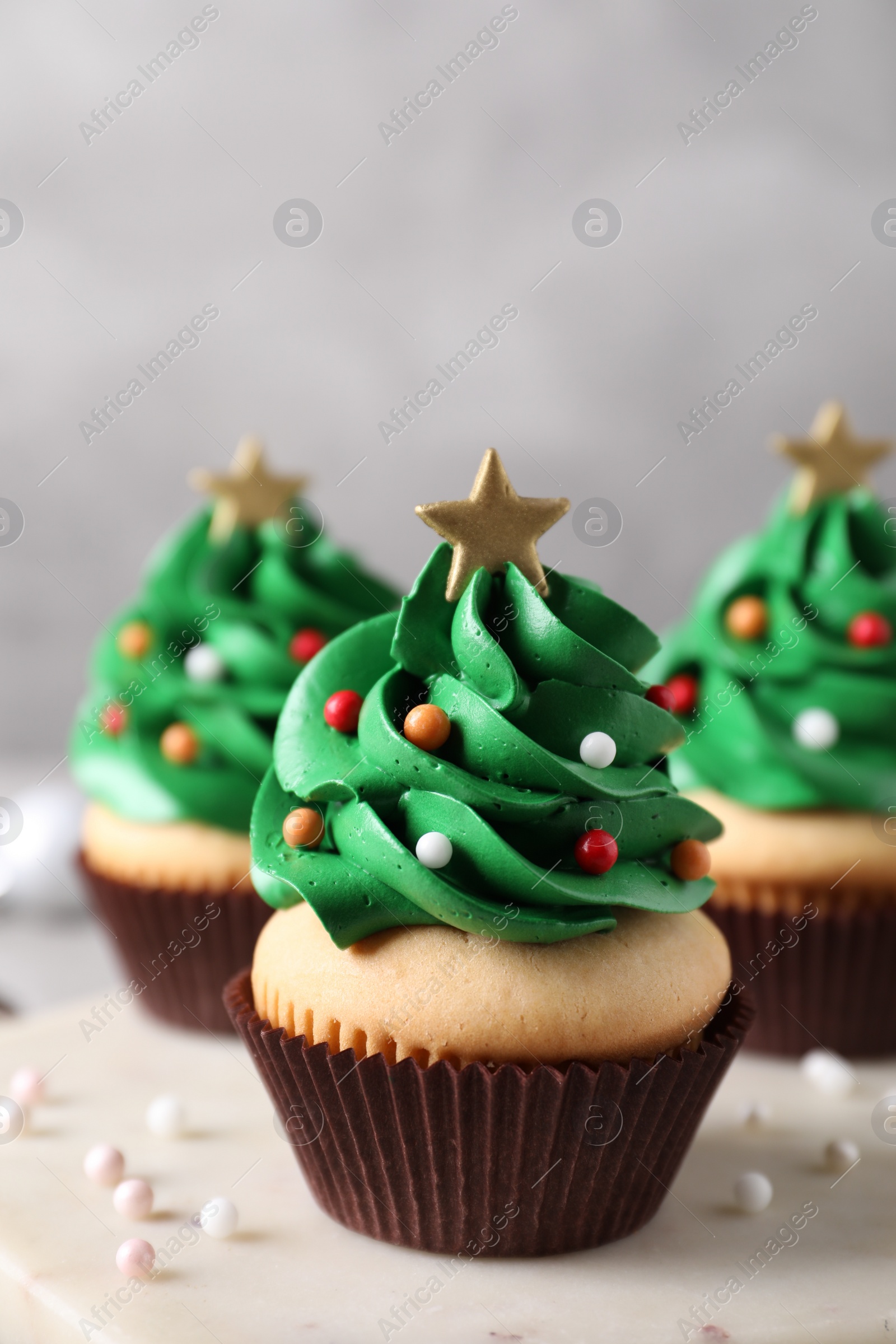 Photo of Christmas tree shaped cupcakes on marble board, closeup