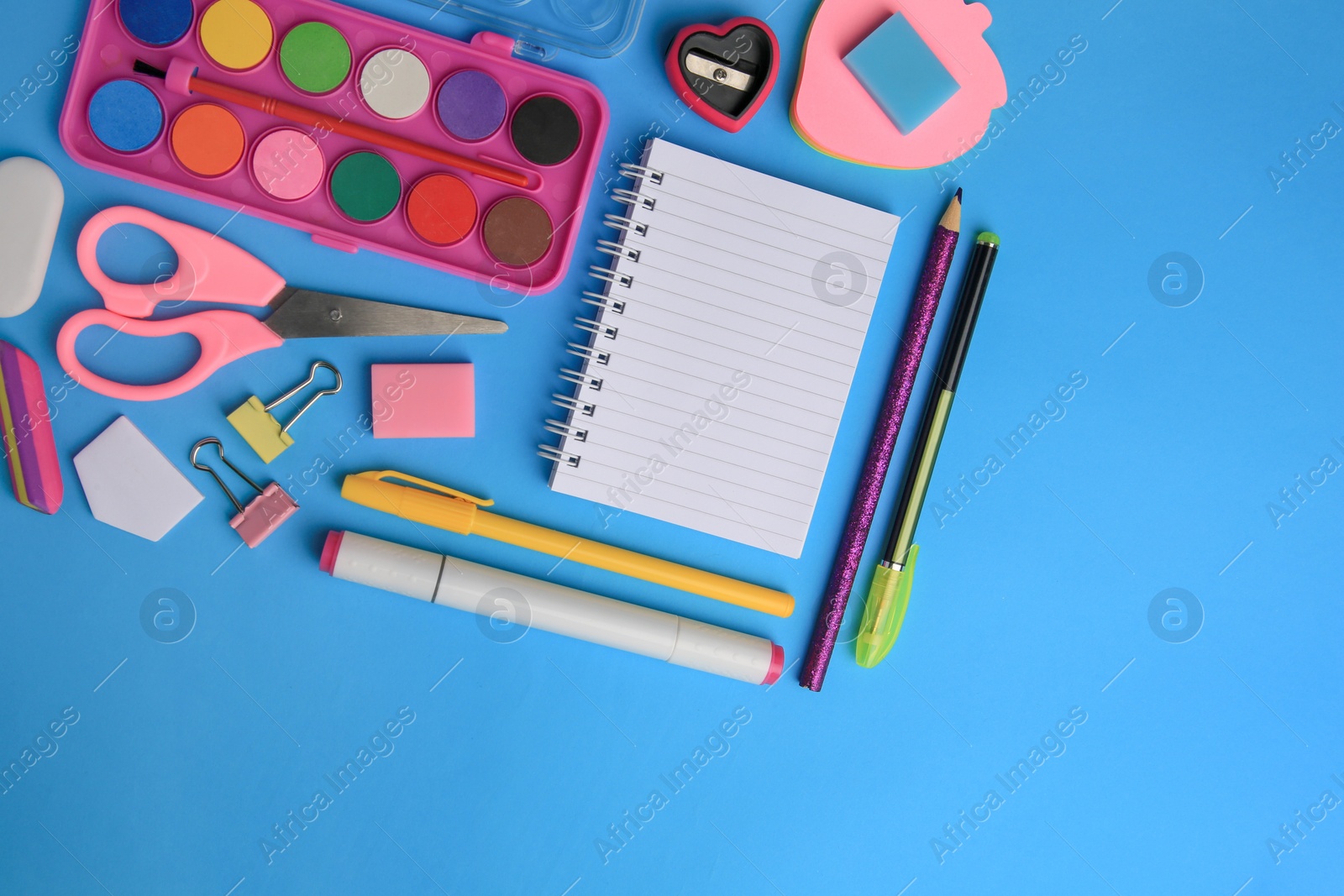 Photo of Flat lay composition with blank notebook and other school stationery on light blue background, space for text. Back to school