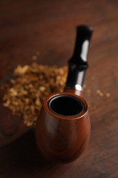 Photo of Tobacco pipe on wooden table, closeup. Space for text