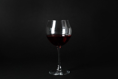 Glass of expensive red wine on dark background