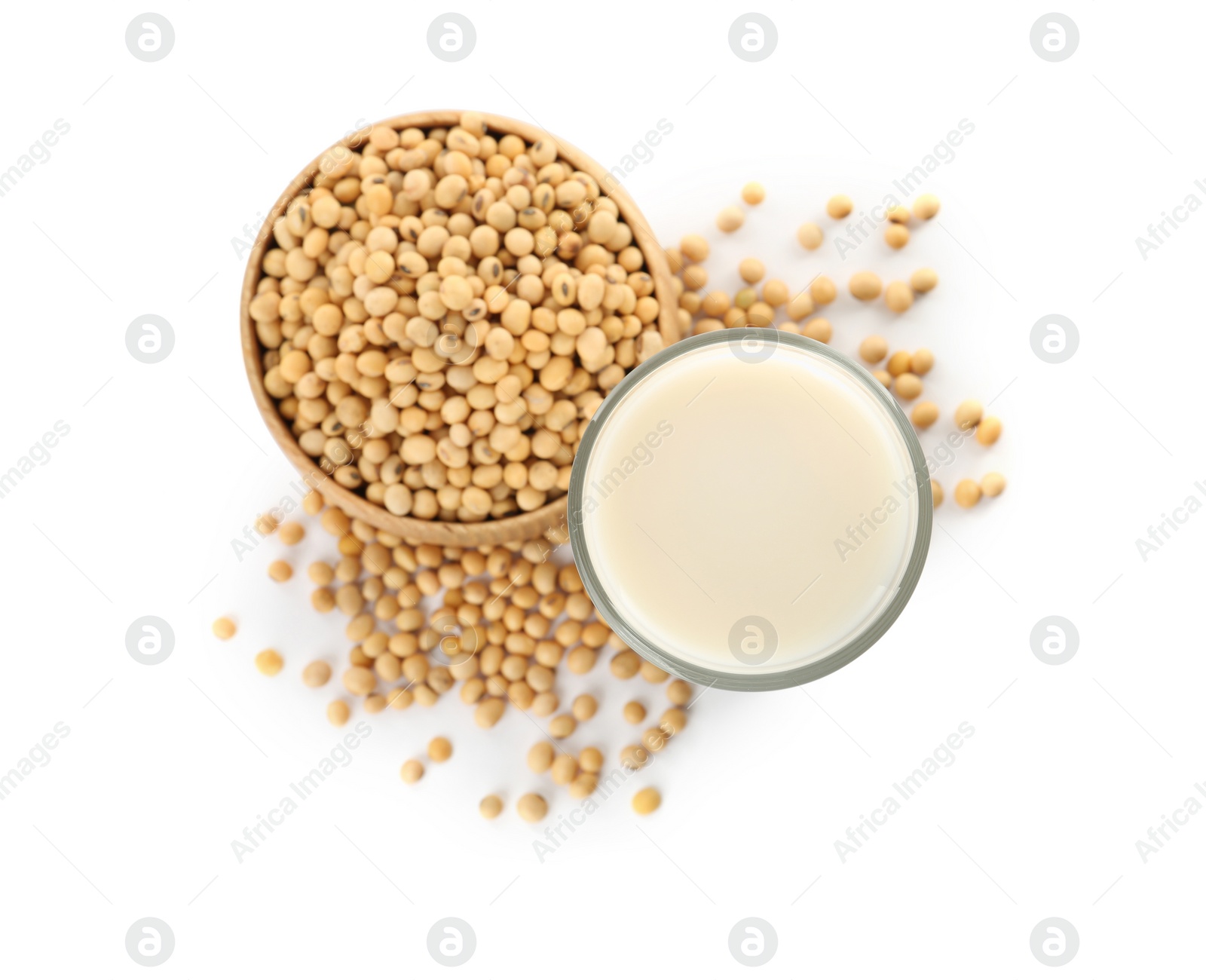 Photo of Glass of fresh soy milk and bowl with beans on white background, top view