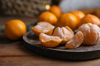 Photo of Tray with delicious ripe tangerines on wooden table, closeup