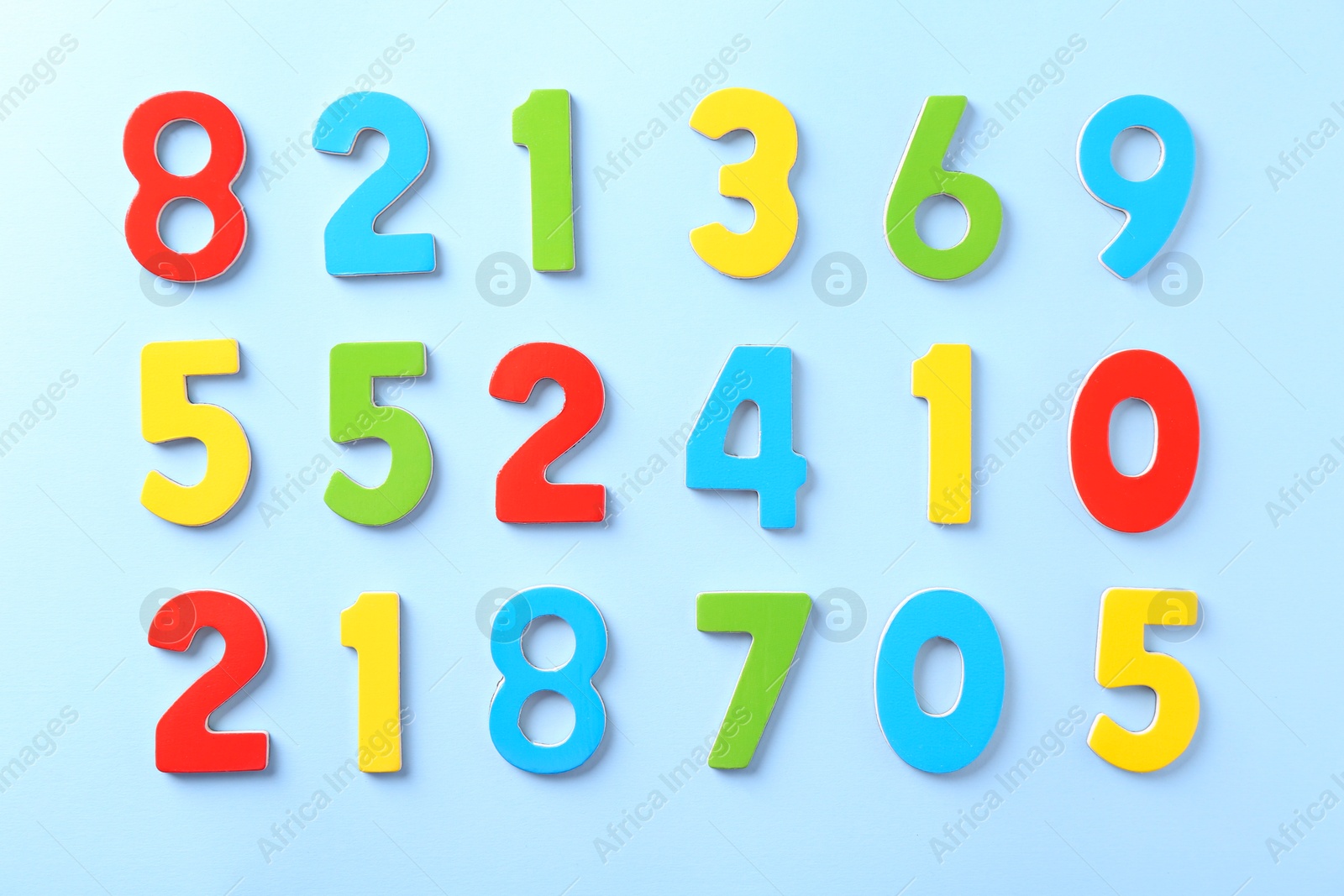 Photo of Colorful numbers on light blue background, flat lay